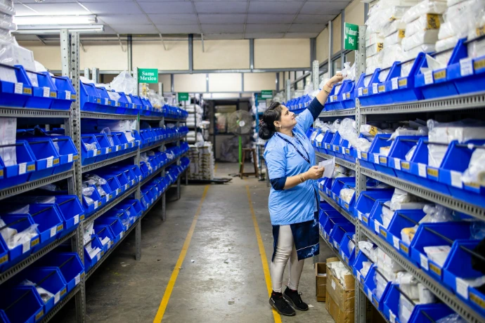 A woman organizes items in a warehouse.
